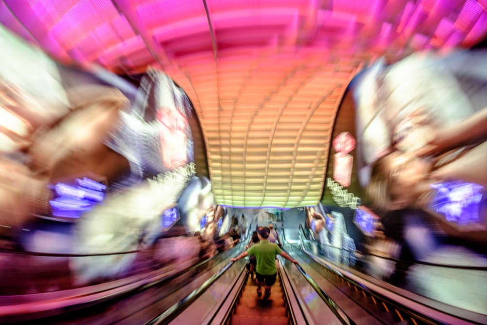 Motion blur in a busy shopping mall escalator through the fisheye
